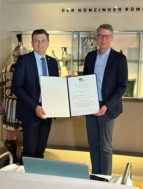 Kunstminister Markus Blume (r.) übergab die Urkunde für die Aufnahme des Donaulimes in die UNESCO-Welterbeliste an den Ersten Bürgermeister von Neustadt an der Donau, Thomas Memmel (l.). 